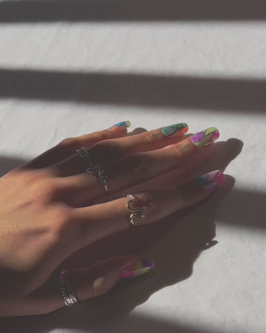 video of multiple short clips showing a hand modeling a set of colorful press on nails